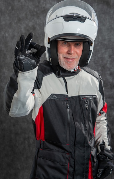 Retrato de motociclista sênior com capacete branco está certo