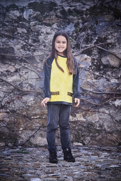 Retrato de mulher adolescente morena sobre pedra cinza.