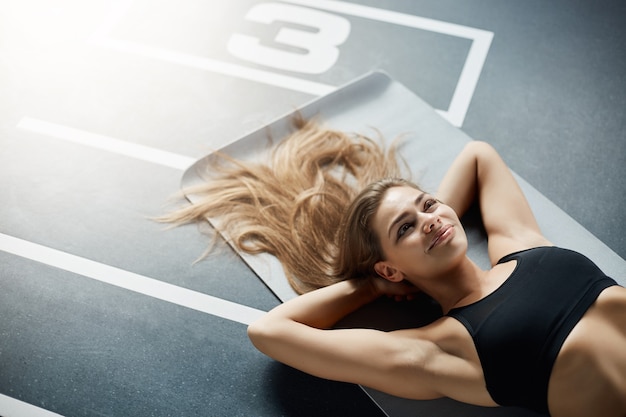 Retrato de mulher adulta feliz após um treino de fitness. descansando e sorrindo. conceito de esportes.