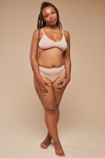Foto retrato de mulher africana com excesso de peso em roupa íntima, isolado no fundo branco