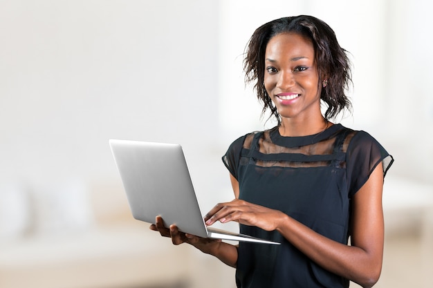 Retrato de mulher africana jovem confiante usando laptop