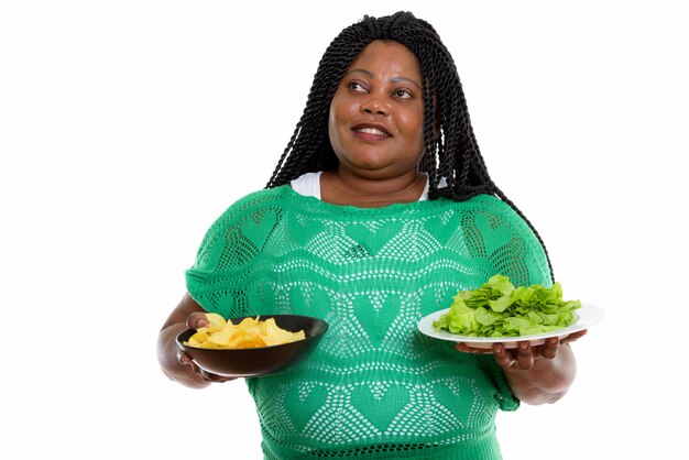 retrato de mulher africana segurando batatas fritas e salada