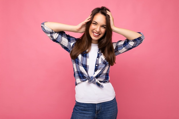 Retrato de mulher alegre positiva na moda em roupa hipster isolada em rosa