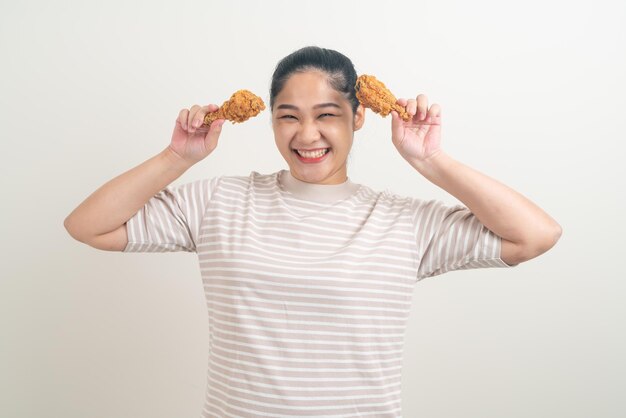 Retrato de mulher asiática com frango frito na mão