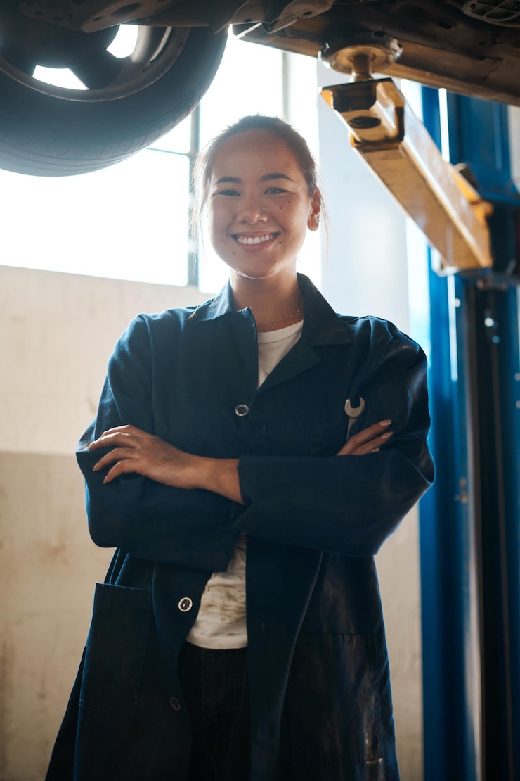 Foto retrato de mulher asiática com os braços cruzados como mecânica de carros na garagem com orgulho pelo crescimento da carreira pessoa feminina confiante e feliz para startup ou pequeno negócio como engenheira de reparos e serviço