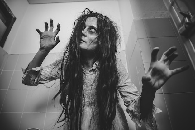 Foto retrato de mulher asiática compõe fantasmacena de terror assustadora para fundoconceito de festival de halloween poster de filmes fantasma espírito raivoso no apartamento