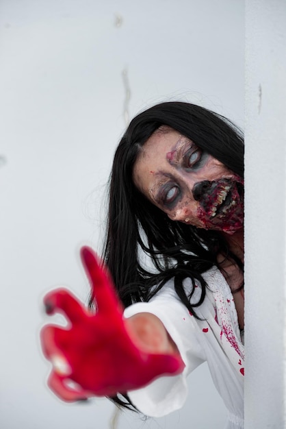 Retrato de mulher asiática compõe rosto de fantasma com sangue em fundo brancoCena de terrorFundo assustadorCartaz de HalloweenPovo da Tailândia