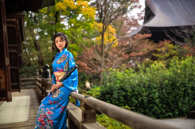 Retrato, de, mulher asiática, desgastar, quimono azul japonês, e, guarda-chuva, segurar mão