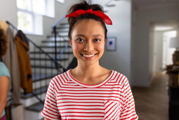 Retrato de mulher asiática feliz com faixa vermelha na cabeça em casa
