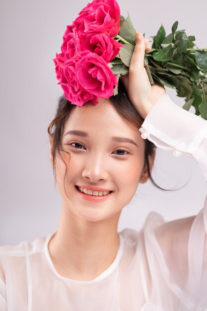 Retrato de mulher asiática fresca com buquê de rosas na mão