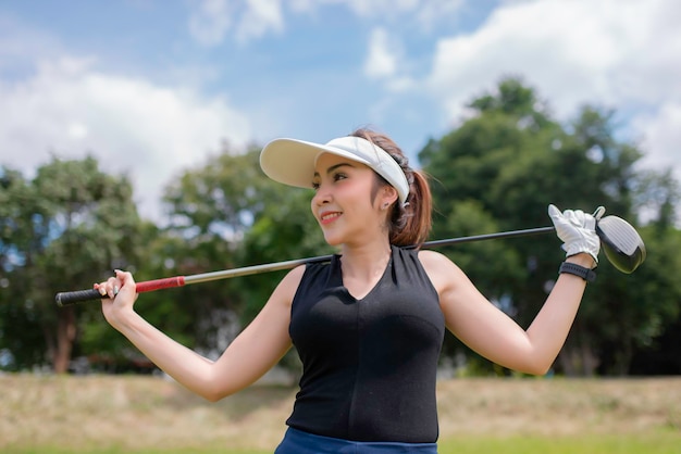 Retrato de mulher asiática golfista segurando madeira de golfe no clube de campoconceito de mulher feliz