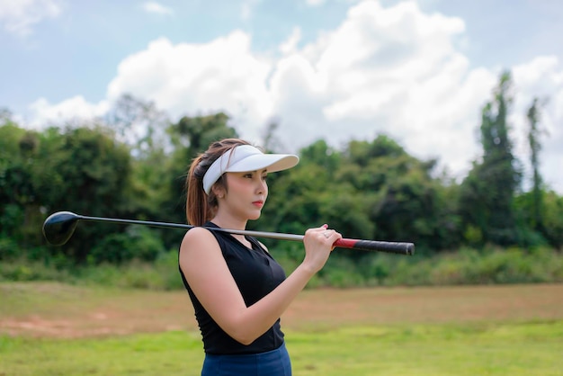 Retrato de mulher asiática golfista segurando madeira de golfe no clube de campoConceito de mulher feliz