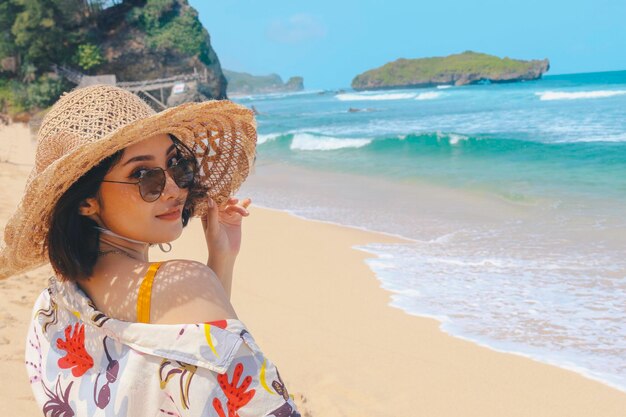 Retrato de mulher asiática sorridente feliz na praia em uma linda menina bonita asiática em casual olhando para longe e sorrindo rindo A praia linda no céu brilhante