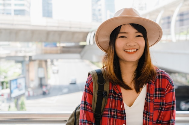 Retrato de mulher asiática sorridente jovem e atraente ao ar livre na cidade