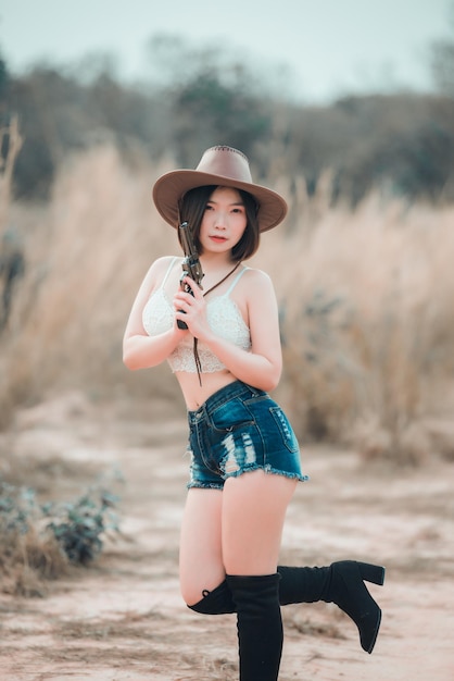 Retrato de mulher asiática usa personagem cowgirl no campoCowboy festival conceptSexy lady pose for take a pictureThailand people