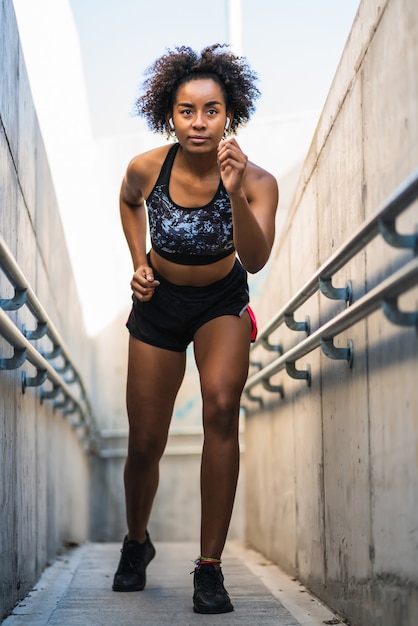 Retrato de mulher atleta afro correndo e fazendo exercício ao ar livre.