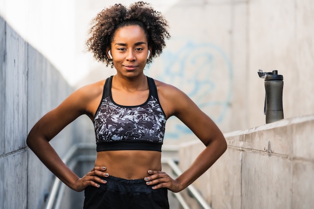 Retrato de mulher atleta afro relaxando após malhar ao ar livre