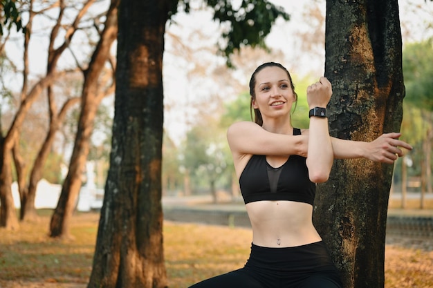 Retrato de mulher atlética se aquecendo antes do treinamento esportivo ao ar livre Esporte fitness e conceito de estilo de vida saudável