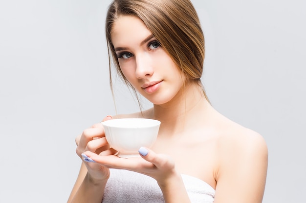Retrato de mulher atraente relaxado após spa-tempo com uma xícara de chá ou café