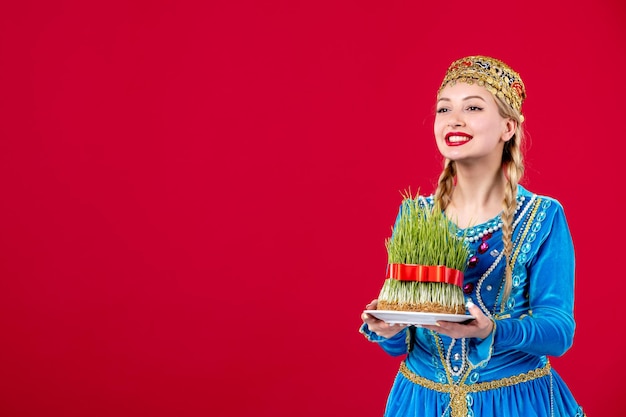 Retrato de mulher azeri em vestido tradicional com sêmen verde na primavera de dançarina de conceito étnico de fundo vermelho