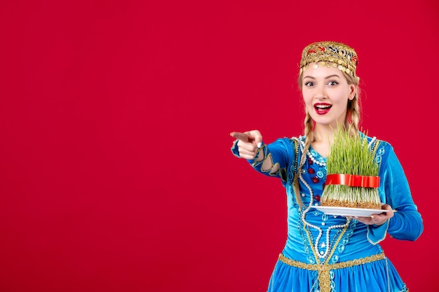 Foto retrato de mulher azeri em vestido tradicional com sêmen verde na primavera de dançarina novruz étnica de fundo vermelho