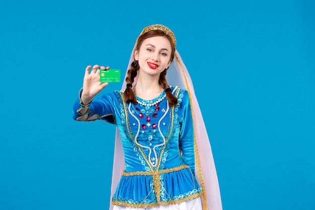 retrato de mulher azeri em vestido tradicional segurando um cartão de crédito verde