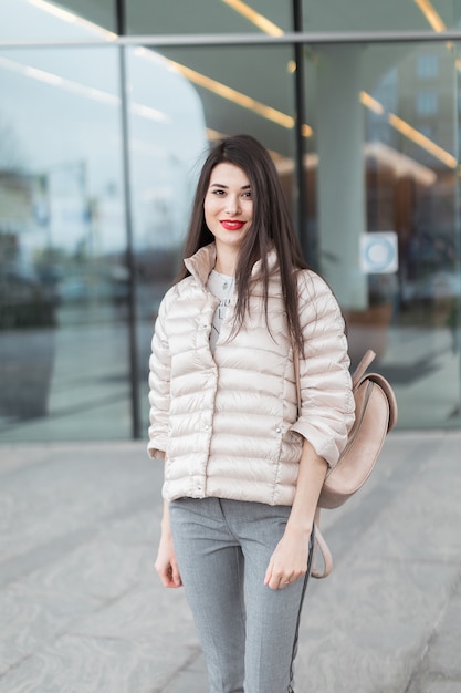 Retrato de mulher bonita com lábios vermelhos e mochila