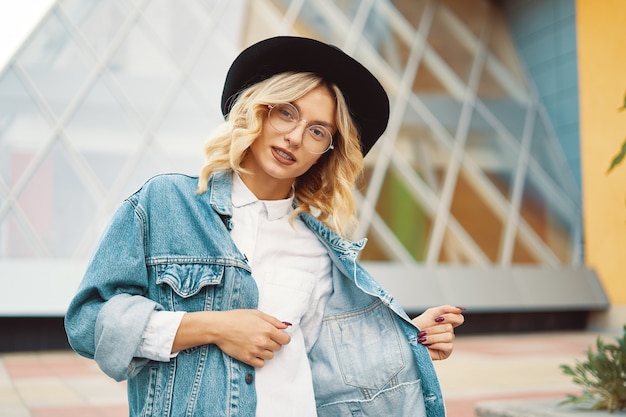 retrato de mulher bonita com óculos e um chapéu ao ar livre