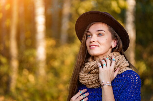 Retrato de mulher bonita feliz morena pensativa outono com cabelos longos, com um chapéu marrom e uma camisola de malha com scart quente ao ar livre no outono