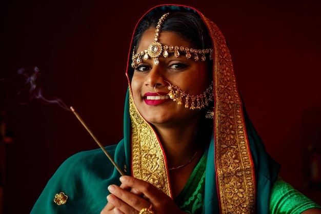 Retrato de mulher bonita indiana em joias ricas em ouro e tradição saree rosto closeup maquiagem profissional usando bindi na cabeça Retrato de rosto de mulher muçulmana com bindis maang tikka nathnose Pin