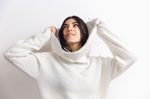 Foto retrato de mulher bonita isolada no fundo branco do estúdio conforto quente no conceito de inverno