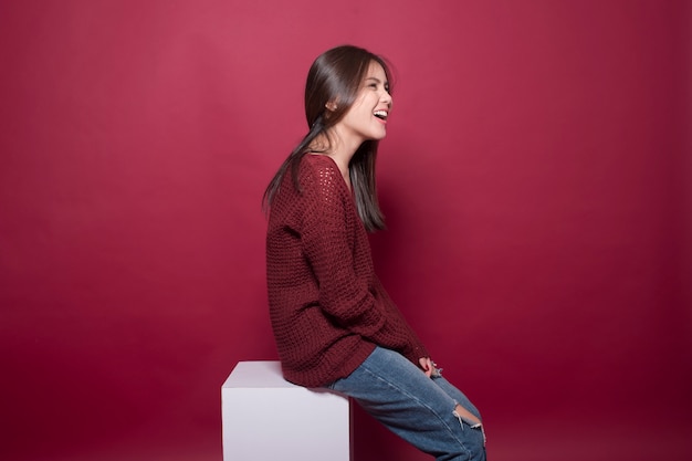 Foto retrato de mulher bonita no studio em fundo vermelho