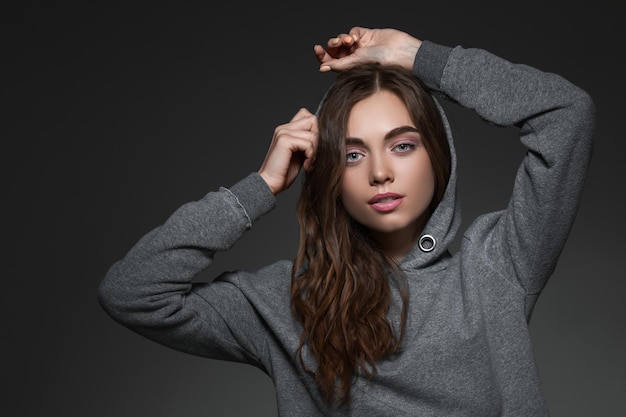 Retrato de mulher com cabelo comprido em suéter cinza