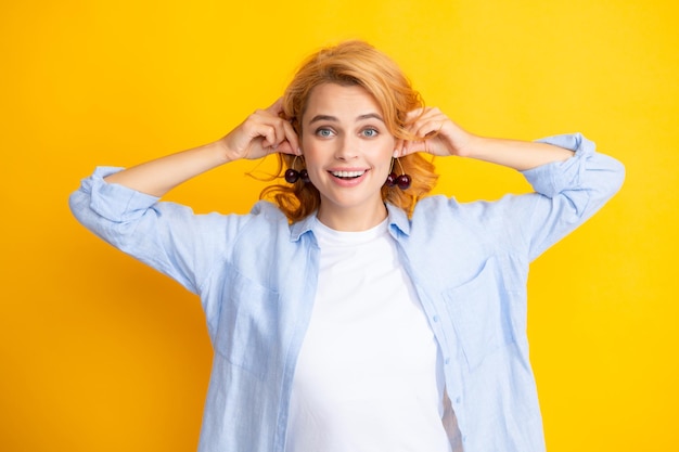 Retrato de mulher com cerejas em fundo isolado de estúdio amarelo