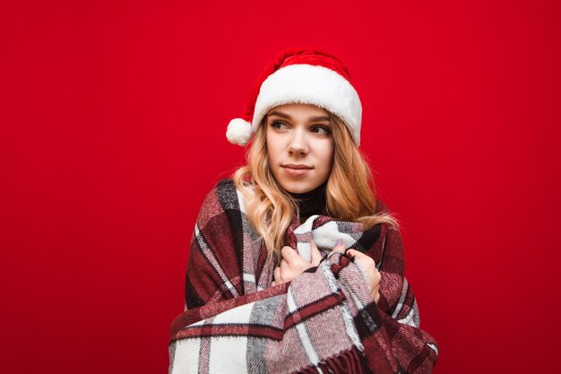 retrato de mulher com chapéu de Papai Noel e cobertor