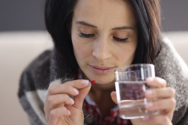 Retrato de mulher com comprimido e copo de água. Conceito de antidepressivos para mulheres