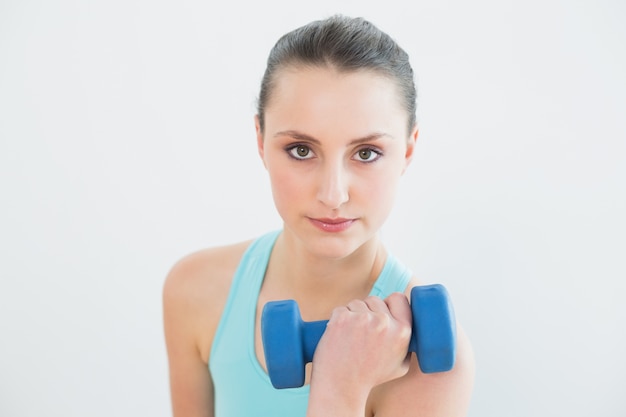 Retrato de mulher com dumbbell contra parede