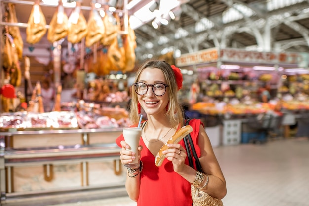 Retrato de mulher com Horchata, bebida tradicional espanhola feita com amêndoas, em pé no mercado de alimentos central da cidade de Valência