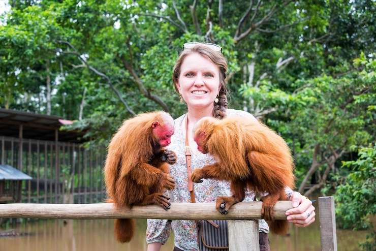 Foto retrato de mulher com macacos uakari carecas