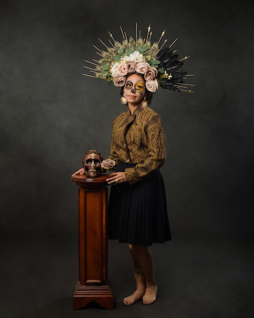 Retrato de mulher com maquiagem de caveira de açúcar segurando uma caveira de Halloween e maquiagem do dia dos mortos