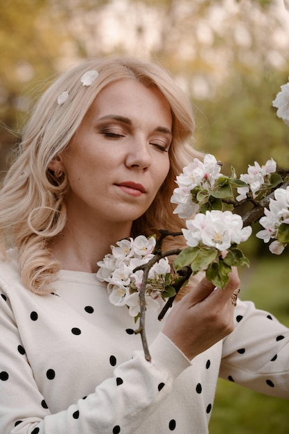 Retrato de mulher com os olhos fechados aproveitando a floração da primavera