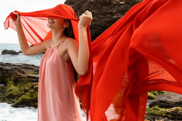 Retrato de mulher com rosto coberto por véu na praia