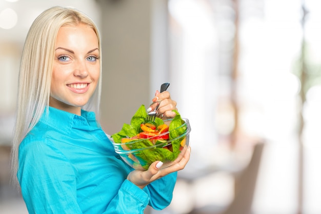Foto retrato de mulher comendo salada verde com tomates