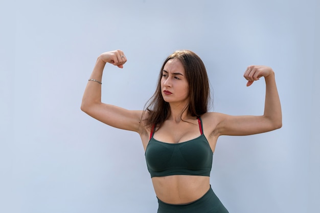 Retrato de mulher de aptidão em sportswear posando isolado em fundo cinza. conceito de saúde e esporte