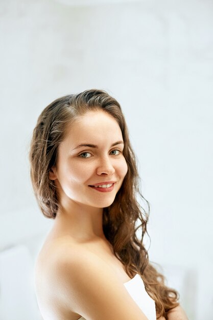 Retrato de mulher de cabelo molhado, conceito de cuidado de pele saudável de cabelo de beleza, bela modelo com cabelo molhado no banheiro.