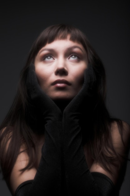 Retrato de mulher de cabelo preto em fundo escuro