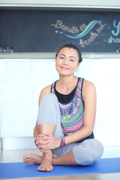 Retrato de mulher de ioga sorridente sentada no tapete de ioga após treino no estúdio de ioga mulher de ioga