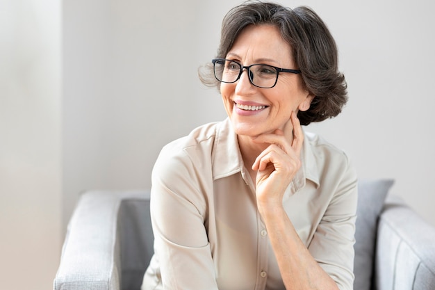 Retrato de mulher de meia-idade sorridente em copos, copie o espaço