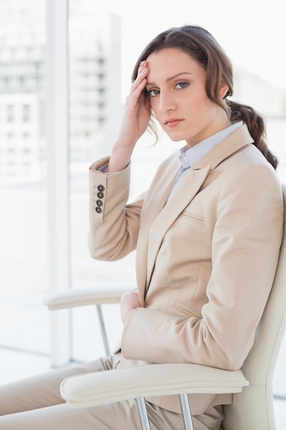 Retrato de mulher de negócios que sofre de dor de cabeça no escritório