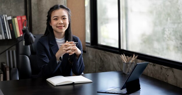 Retrato de mulher de negócios sentada em uma mesa de escritório trabalhando em um laptop no escritório Empresária bem-sucedida